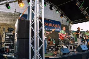 Band auf Bühne während eines Konzerts mit Fokus auf die Tontechnik