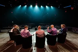 Blick auf eine Konferenz im Studio4.DIGITAL aus Richtung der Bühne mit Blick auf das Publikum und die Referenten von hinten